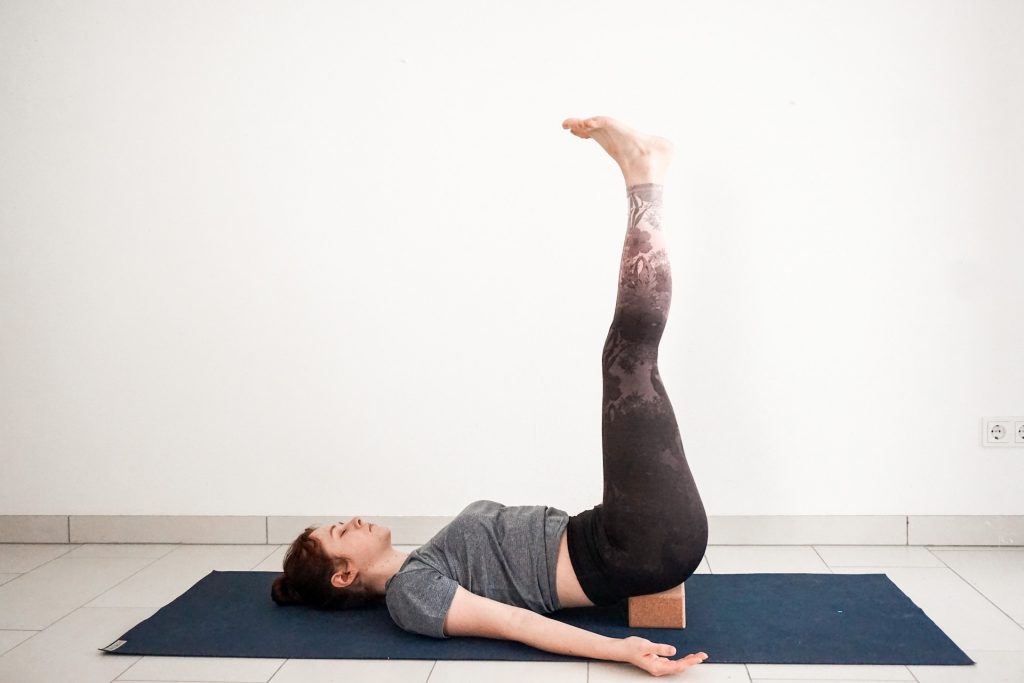 how to use yoga block in viparita karati for beginners - legs up the wall pose in the middle of the room