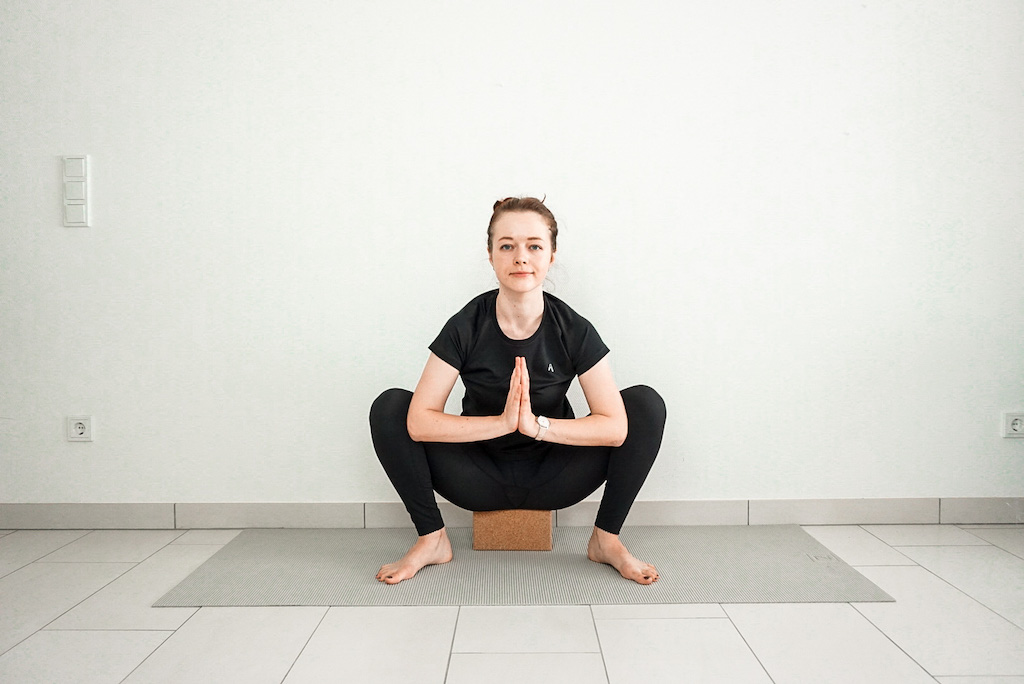 garland pose with yoga block for beginners