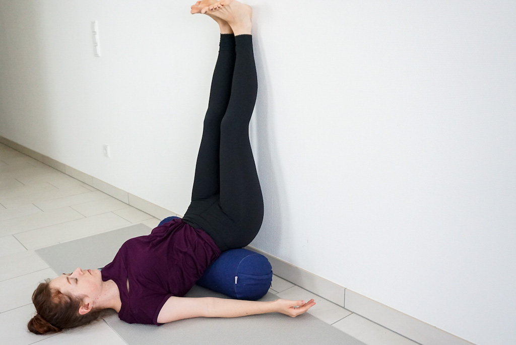 legs up the wall pose with bolster