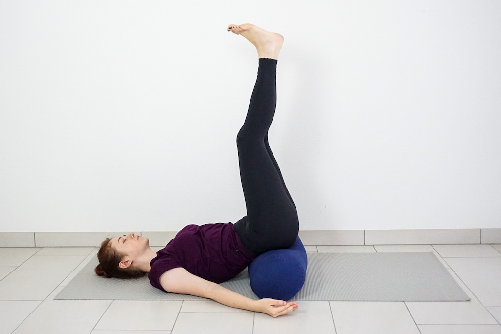 legs up the wall pose with yoga bolster