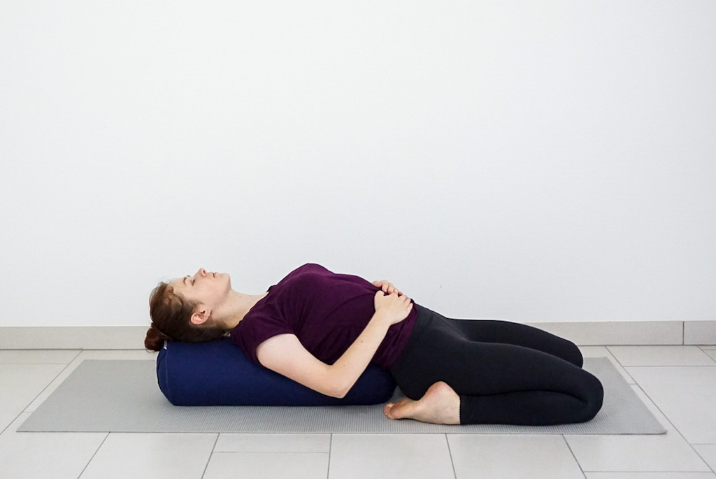 reclined hero pose with yoga bolster
