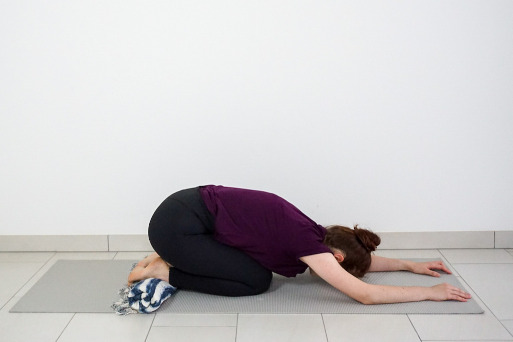 yoga blanket under ankles in childs pose