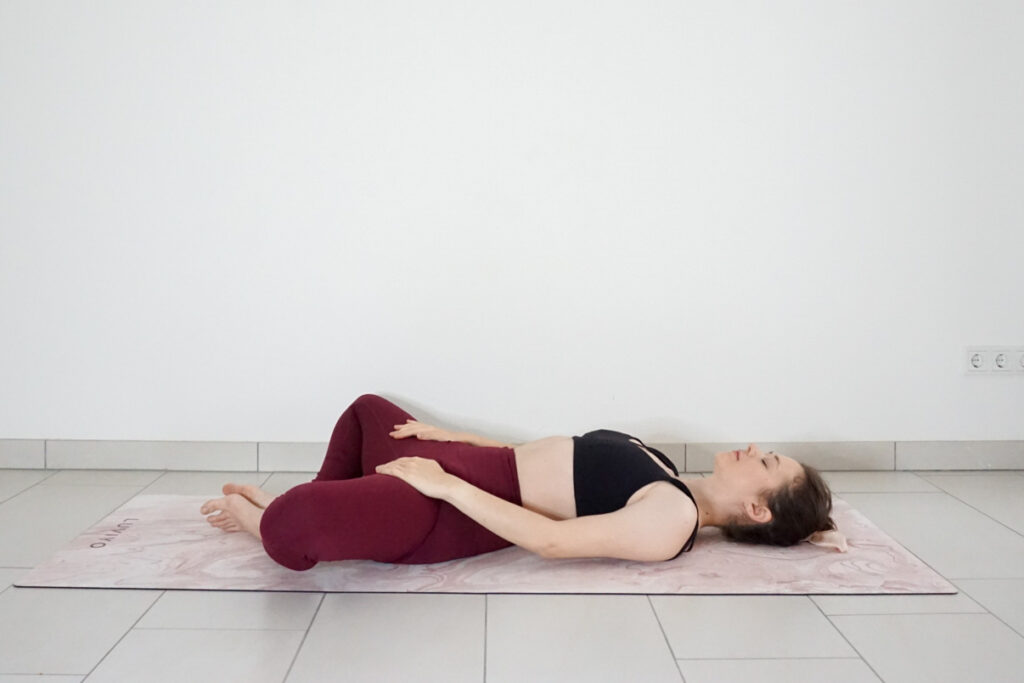 reclined butterfly pose with hands on thighs